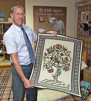 Timothy Booth holding a Carpets of Caring tapestry.